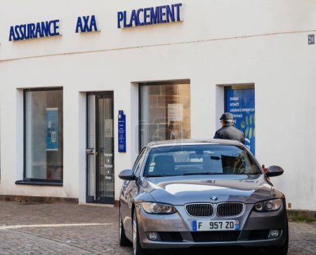Photo for Haguenau, France - Mar 20, 2024: Exterior of AXA Insurance office with distinctive branding, providing services in assurance, investment, and banking to clients in the area with luxury BMW car parked - Royalty Free Image