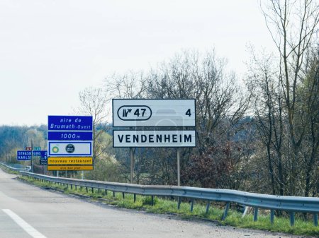 Foto de La señalización de la autopista se dirige a Brumath Ouest y Vendenheim en Francia, con un panel informativo para la gasolinera BP y el Café Marie Blachere. - Imagen libre de derechos