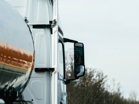 Téléchargez les photos : Une vue détaillée du côté d'un semi-camion, mettant en valeur ses grandes roues, ses panneaux métalliques et ses détails réfléchissants. - en image libre de droit