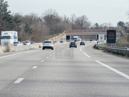 Téléchargez les photos : Strasbourg, France - 20 mars 2024 : Panneau numérique de limitation de vitesse sur autoroute affichant une restriction de 110 kmh, illustrant les conditions de circulation réglementées sur l'A35 français - en image libre de droit