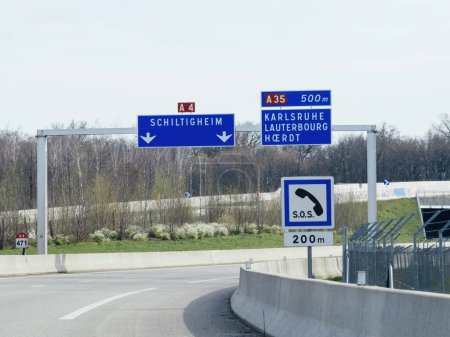 Téléchargez les photos : Panneau de signalisation sur l'autoroute française A35 indiquant les distances jusqu'à Schiltigheim, Karlsruhe, Lauterbourg et Hoerdt - en image libre de droit
