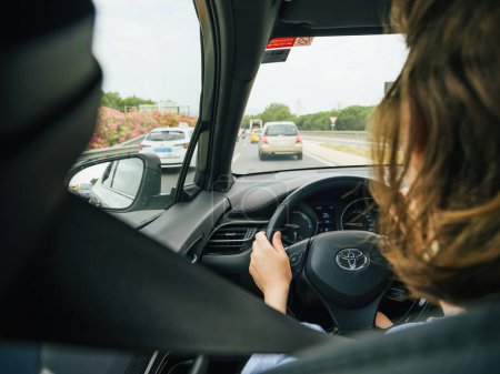 Téléchargez les photos : Majorque, Espagne - 28 juin 2023 : Une femme au volant d'une Toyota naviguant dans la circulation diurne à Majorque, Espagne - en image libre de droit