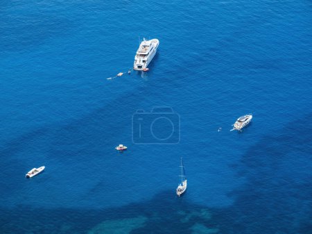 Aerial view of several boats are peacefully floating on the water near Sa Foradada, Mallorca Spain - relaxing people swimming sunbathing
