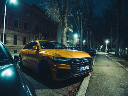 Photo for Strasbourg, France - Dec 23, 2023: An Audi SUV stands out with its vibrant hue against the night backdrop in Strasbourg, showcasing automotive elegance and urban style. - Royalty Free Image