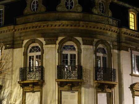 Foto de Un enorme edificio en Francia adornado con numerosas ventanas y balcones, bullicioso en la víspera de Navidad. - Imagen libre de derechos