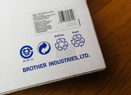Téléchargez les photos : Paris, France - 9 mars 2024 : Gros plan sur les logos de recyclage pour l'UE, la Chine et la Russie, ainsi que sur l "étiquette importée et l" étiquette Made in Vietnam sur la boîte à coudre Brother - en image libre de droit