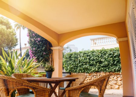Téléchargez les photos : L'arche accueillante d'une villa majorquine s'ouvre sur un jardin mural en pierre, où lierre luxuriant et bougainvilliers créent une oasis privée - en image libre de droit
