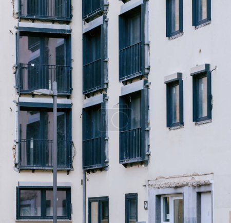 Téléchargez les photos : Rénovation de l'immeuble d'appartements avec de nouvelles installations de fenêtres, balcons et isolation améliorée. - en image libre de droit