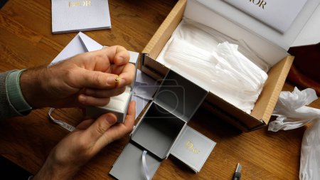 Photo for Paris, France - Sep 14, 2023: A mans hands elegantly present a Dior jewelry box, signifying a luxurious unboxing experience - Royalty Free Image
