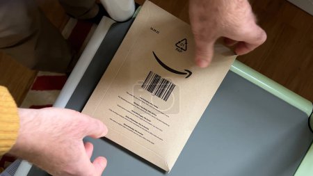 Photo for Frankfurt, Germany - Mar 31, 2024: A persons hand opens an Amazon package with a high-efficiency filter inside - Royalty Free Image