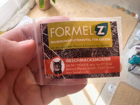 Photo for Frankfurt, Germany - Sep 13, 2022: Close-up of a hand holding a FORMEL-Z cat supplement package with natural vitamin B complex, with a clear expiration date - Royalty Free Image
