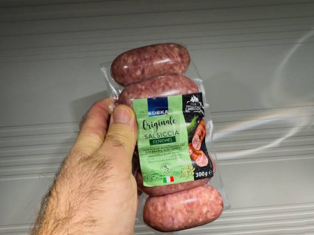 Photo for Frankfurt, Germany - Mar 9, 2024: A male hand holds Edekas original Salsiccia sausages with fennel, showcasing Mediterranean food made in Italy - Royalty Free Image
