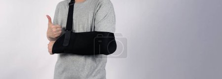 Photo for Broken arm. Arm Sling therapy support and covered around elbow first knuckle broken arm. Post Operative Care. Fractures of humerus radius ulna scapula. Arm Sling after accident. Isolated background. - Royalty Free Image