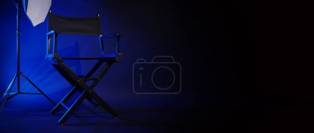 Photo for Director chair with cinema lightbox sign Director text on it and clapperboard megaphone and black background studio. Director seat on video production or filming set used in film industry. Real no 3D - Royalty Free Image