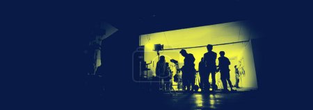 Foto de Detrás de las escenas de rodaje de producción de vídeo y el conjunto de iluminación para la filmación de la película que el equipo de filmación que trabaja en la silueta y el equipo profesional en el estudio de vídeo en línea. producción de vídeo - Imagen libre de derechos