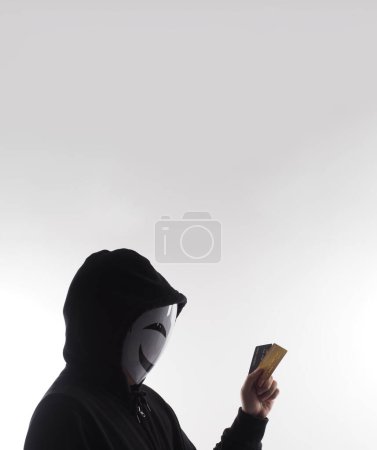 Foto de Hombre hacker y tarjetas de crédito en la mano. Representar los datos personales de tarjetas de crédito robados por un hombre anónimo con camisa de capucha negra. Tarjetas de crédito de seguridad de datos y ciberdelincuencia digital. Transección de dinero sin garantía. - Imagen libre de derechos