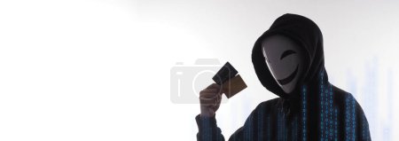 Téléchargez les photos : Un pirate et des cartes de crédit en main. Représenter les données personnelles des cartes de crédit volées par un homme anonyme en chemise Black hood. Sécurité des données des cartes de crédit et cybercriminalité numérique. Transection d'argent non sécurisée. - en image libre de droit