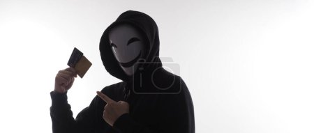 Photo for Hacker man and credit cards in hand. Represent credit cards personal data stolen by anonymous man in Black hood shirt. Credit cards data security and Cyber crime digital. Money transection unsecured. - Royalty Free Image
