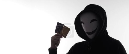 Foto de Hombre hacker y tarjetas de crédito en la mano. Representar los datos personales de tarjetas de crédito robados por un hombre anónimo con camisa de capucha negra. Tarjetas de crédito de seguridad de datos y ciberdelincuencia digital. Transección de dinero sin garantía. - Imagen libre de derechos