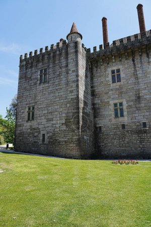 Paredes del castillo en la ciudad europea de Guimaraes en Portugal, cielo azul claro en 2022 cálido día soleado de primavera en mayo vertical