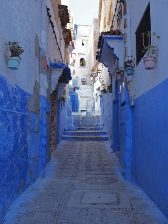 Photo for Bluish frontage in african Chefchaouen city in Morocco, clear blue sky in 2019 warm sunny spring day on April - vertical - Royalty Free Image