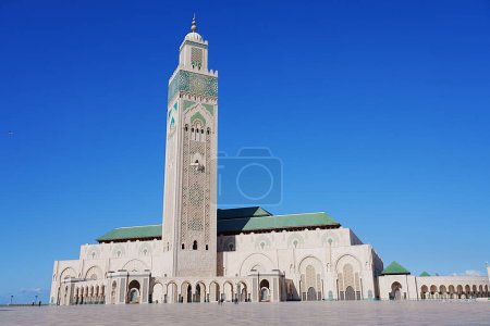 View to Hassan II mosque with minaret at african Casablanca city in Morocco, clear blue sky in 2023 warm sunny winter day on January.