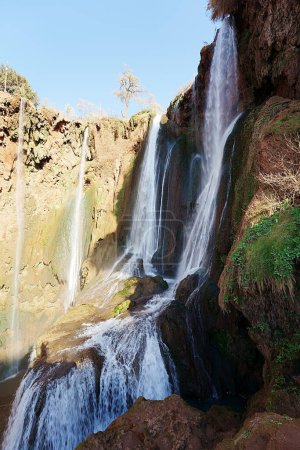 Landschaftlich reizvolle Ouzoud-Wasserfälle in der Provinz Azilal in Marokko, strahlend blauer Himmel im Jahr 2023 warmer, sonniger Wintertag im Januar - senkrecht