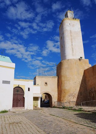 Mezquita con antiguo faro portugués en la ciudad africana de MAZAGAN en Marruecos, cielo azul claro en 2023 cálido día de invierno soleado en enero - vertical