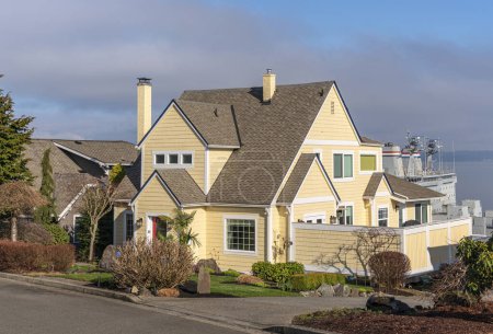 Téléchargez les photos : Maison jaune dans une banlieue de l'État de Tacoma Washington avec la nature environnante. - en image libre de droit