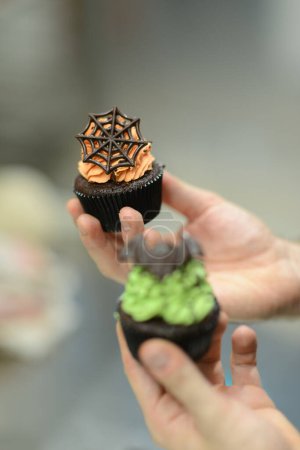 Photo for Artisan chef preparing handmade with icing and chocolate spider vampire topper - Royalty Free Image