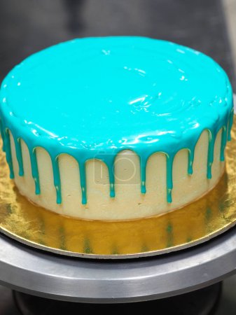 Photo for Bag piping filling topping on frosted icing drip turquoise cake for birthday celebration - Royalty Free Image