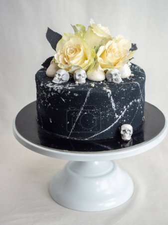 Foto de Cumpleaños aerografo negro pintado pastel de hielo esmerilado, dos rosas reales plata pulverizada y comestible cráneo de chocolate toppers y trazos de cepillo de plata - Imagen libre de derechos