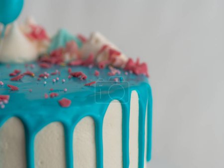Photo for Studio shot of chocolate frosted blue dripped icing white cup cake, unicorn , meringue and sprinkles on top - Royalty Free Image