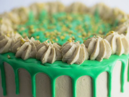 Photo for Studio shot of green pistachio frosted dripped icing cup cake - Royalty Free Image