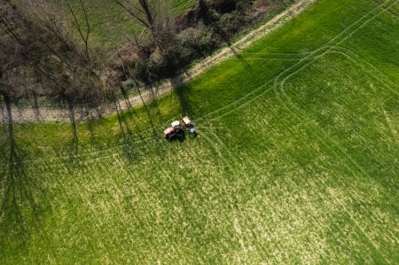 Foto de Agricultor que conduce tractor arrastrado cuesta arriba en la granja durante la temporada de primavera - Imagen libre de derechos