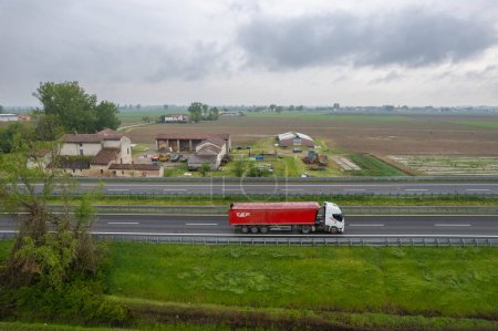 Téléchargez les photos : Piacenza, Italie - Avril 2023 Camions et voitures dans l'autoroute a1 autostrada del seul point de vue aérien entre les champs ruraux plaine de la douleur - en image libre de droit