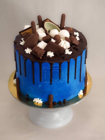 Foto de Macro de pastel de glaseado azul de cerca con glaseado de chocolate negro y dulces mezclados como cobertura aislada sobre fondo blanco para la celebración - Imagen libre de derechos
