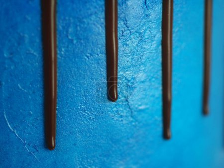 Foto de Macro de pastel de glaseado azul de cerca con glaseado de chocolate negro y dulces mezclados como cobertura aislada sobre fondo blanco para la celebración - Imagen libre de derechos