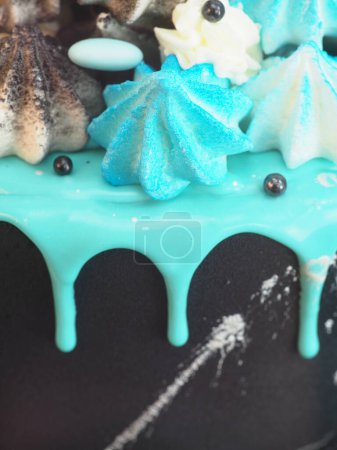 Foto de Pastel de taza pintada negro esmerilado con goteo de turquesa azul y coloreado merengue hecho a mano estudio de cobertura fondo aislado blanco - Imagen libre de derechos