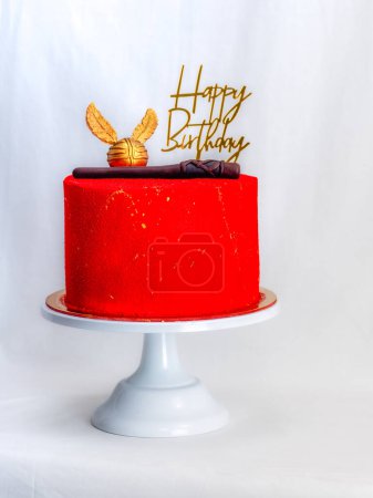 Photo for Red painted frosted cake with golden topping isolated on white background - Royalty Free Image