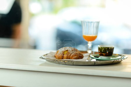 Photo for Good morning breakfast concept with croissant, espresso coffee and fresh orange juice on bar counter, daylight, indoors. - Royalty Free Image