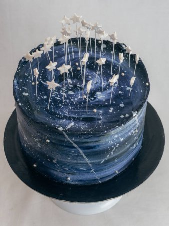 Foto de Pastel de taza de hielo esmerilado para el cumpleaños representan una paleta de cielo estrellado azul negro y estrellas como toppers aislados en el estudio - Imagen libre de derechos