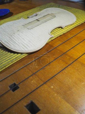 Foto de Nueva placa superior de violín clásico hecho a mano en luthier maker escritorio tiras de madera negro ronroneo incrustaciones en el proceso de canal - Imagen libre de derechos