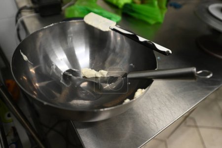 Foto de Pastelero preparar crema de queso de color comestible y espátula para la preparación de la torta esmerilada en una cocina profesional vista aérea - Imagen libre de derechos