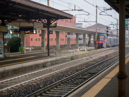 Foto de Fidenza, Italia - 9 de febrero de 2024 Un tren de cercanías Trenitalia se representa estacionario en la plataforma, con la luz descolorida del atardecer fijando un ambiente tranquilo por la noche. - Imagen libre de derechos