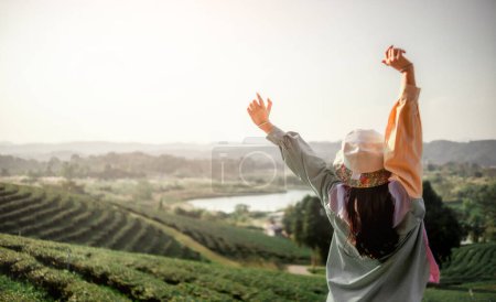Foto de Feliz joven mujer disfrutando de la libertad con las manos abiertas en la montaña. Despreocupada Mujer Feliz respirando Disfrutando de la vista de la naturaleza en el acantilado de la montaña. Al aire libre, concepto de libertad, viaje, vida, - Imagen libre de derechos
