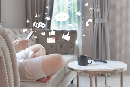 Photo for Connection application technology concept. Man relaxing and shopping online on Smartphone at home. Person using a social media on mobile phone with icons of message, like, comment, wifi, cart, - Royalty Free Image