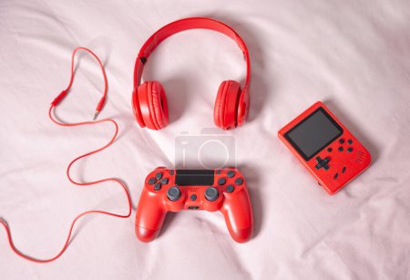 Téléchargez les photos : Gadgets ensemble rouge pour fond de gamer. Gamepads, joystick, écouteurs, casque sur ton rouge et rose - en image libre de droit
