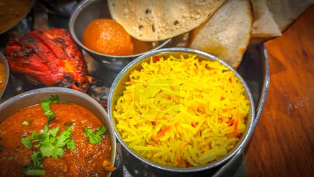 Téléchargez les photos : Cuisine indienne traditionnelle. Assortiment de nourriture indienne sur la table dans le restaurant. apéritifs et plats de la cuisine indienne. Curry, riz, samosa, naan, poulet au beurre, chutney, épices, Palak Paneer, Tikka, Roti - en image libre de droit