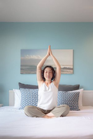 Photo for Asian woman practicing yoga lesson at home. Asian woman housewife's hobby Online training practicing yoga , breathing, meditating smiling relaxed, for Well being, wellness - Royalty Free Image